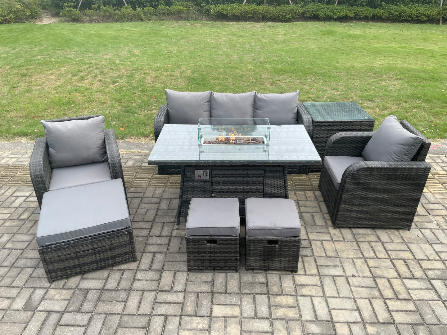 Dark grey wicker rattan garden set with gas fire pit table, 3-seater sofa, and reclining chairs.