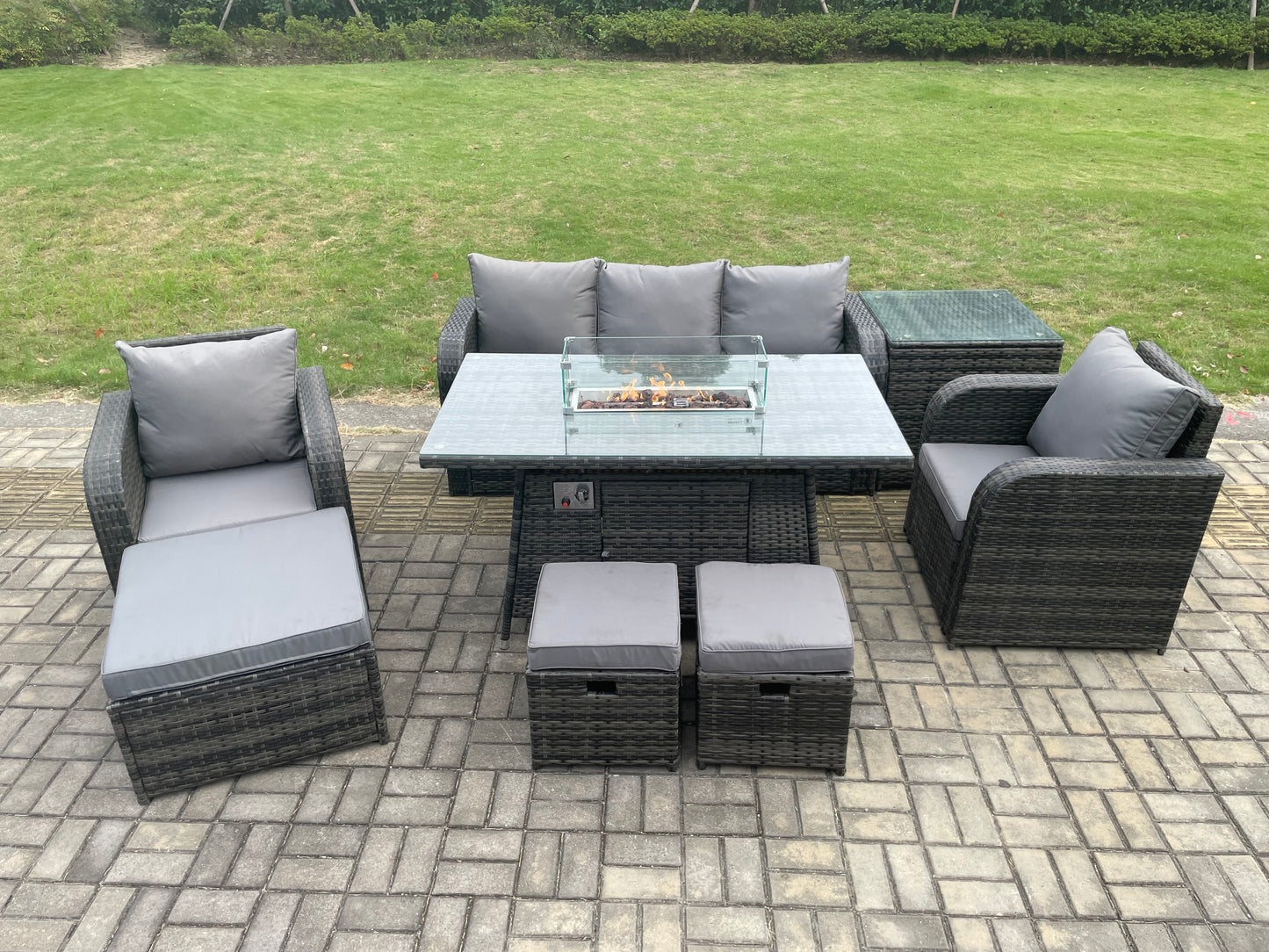 Dark grey wicker rattan garden set with gas fire pit table, 3-seater sofa, and reclining chairs.
